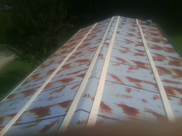 Rusted metal roof panels with new wood purlins before replacement — Storm Damage Roof Repair in Deepwater by Roofing Brothers