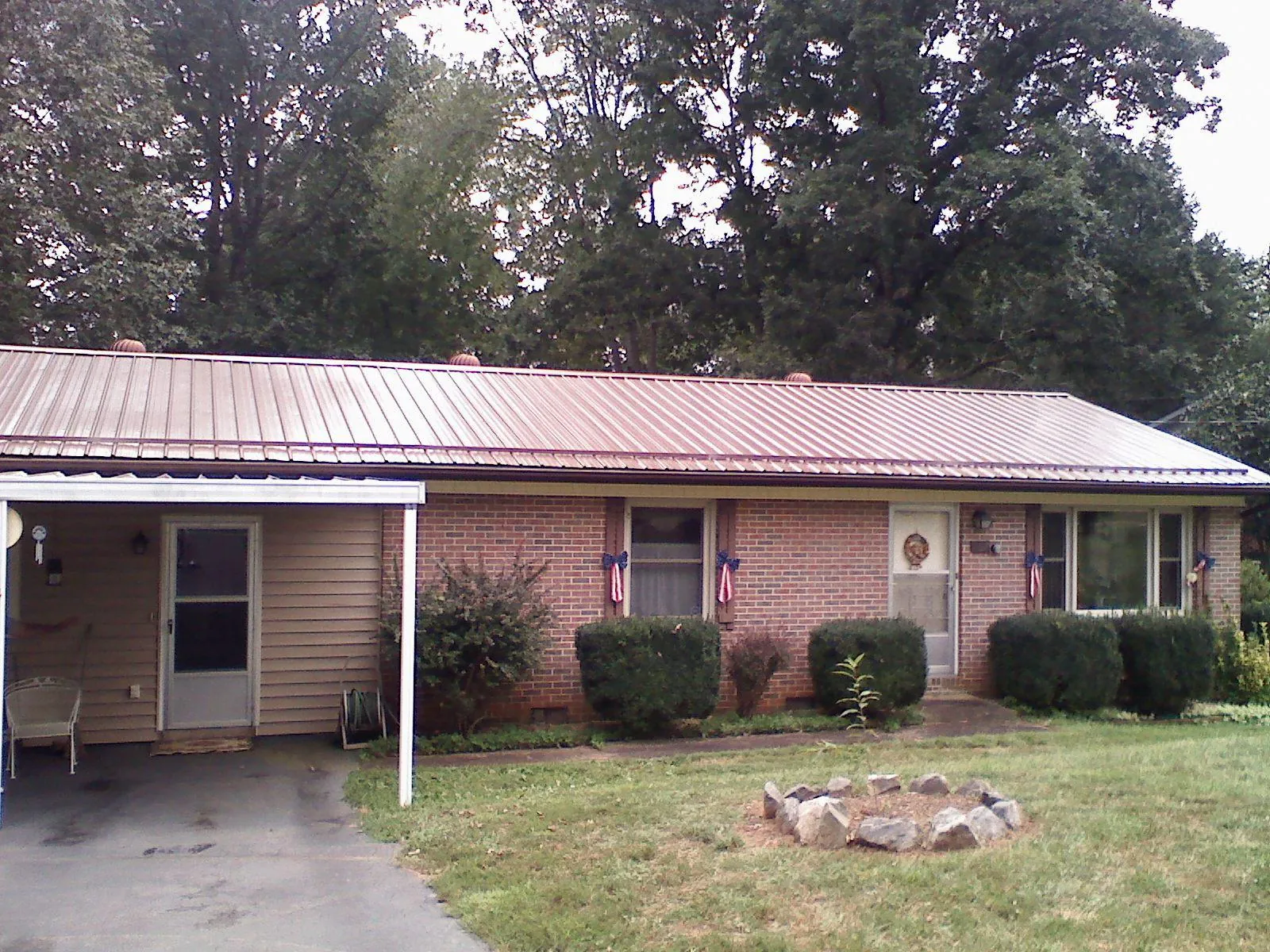 Bronze metal roof and carport on a brick ranch home — Roof Repair work by our crew in Deepwater